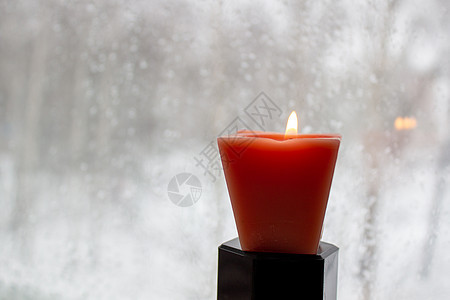 冬天晚上 烛光在寒冷的窗口附近燃烧着蜡烛温暖季节框架窗户玻璃风格建筑学窗台紫色装饰图片