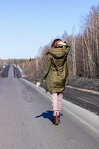 一名年轻妇女在路边走过 森林中的道路头发国家场地季节街道天气冒险天空成人日光图片