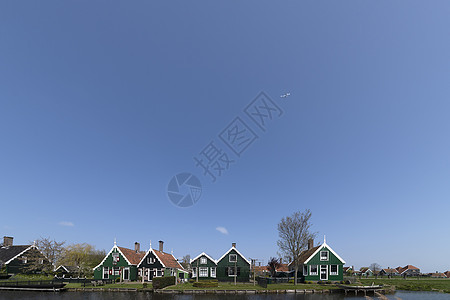 飞机飞越荷兰绿色农村住宅上空 在运河边缘的明蓝阳光晴朗的天空中飞翔农业房子农场建筑运河国家建筑学蓝色图片