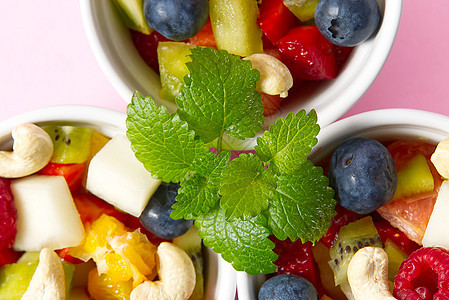 在白色碗的新鲜水果沙拉 白碗健康食品风格的混合水果 有用的水果沙拉 包括粉红色背景的新鲜水果和浆果 三碗水果沙拉小吃饮食芹菜餐厅图片