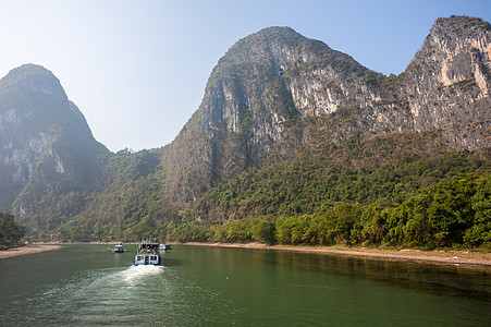 李河巡航和喀斯特在吉林形成山地风景的轮船森林顶峰蓝色地质学农村旅游岩溶晴天天空山脉图片