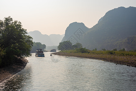 李河巡航和喀斯特在吉林形成山地风景的轮船薄雾岩溶场景森林顶峰天空晴天旅游农村山脉图片