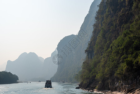 李河巡航和喀斯特在吉林形成山地风景的轮船石灰石反射爬坡旅游森林场景农村薄雾地标岩溶图片