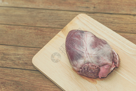 木制切割板上的新鲜猪心娱乐食物猪肉厨房心绞痛卫生烹饪烧烤市场活力图片