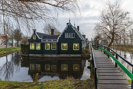 在位于荷兰阿姆斯特丹北部的镇静运河上仿照着美丽和典型的荷兰木制房屋建筑城堡公园天空房子森林木头花园旅行太阳历史图片