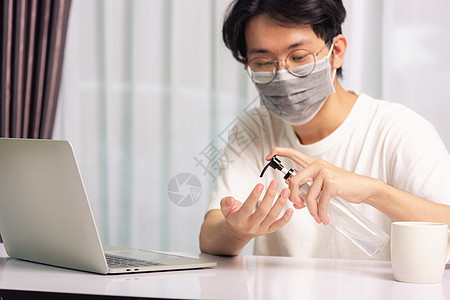 商业青年在家庭办公室工作 他隔海隔离疾病凝胶流感工人桌子感染家居大学口罩电脑图片