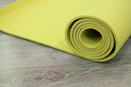 木地板上的瑜伽垫运动地面健身房训练绿色床垫冥想俱乐部运动鞋房间背景图片