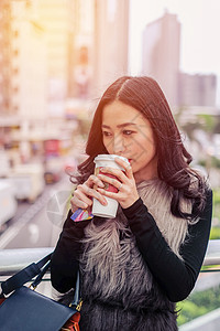 女人在户外街喝咖啡 日出时流图片