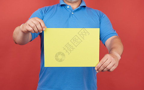穿蓝色衣服的男人在背上拿着一张黄纸的空纸图片
