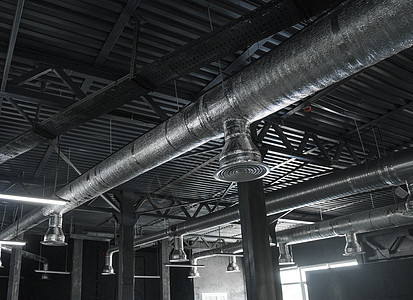 大型建筑物天花板上的通风系统 新建筑天花板上悬挂着银色绝缘材料的通风管冷却冷气机金属工程建造办公室空气基础设施安装暖通图片