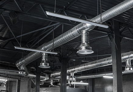 大型建筑物天花板上的通风系统 新建筑天花板上悬挂着银色绝缘材料的通风管空气空调工程管道金属护发素技术暖通冷却安装图片