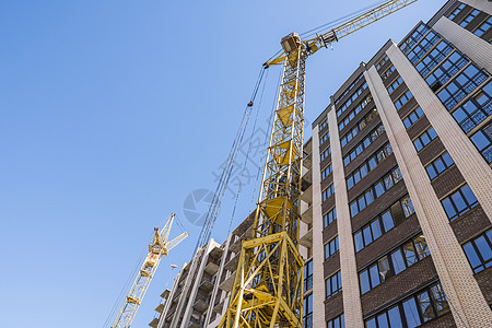 用起重机建造高层建筑 使用模板的建筑施工 起重机和建筑物映衬着蓝天日落操作员住房框架摩天大楼房子机械生长蓝色活动图片