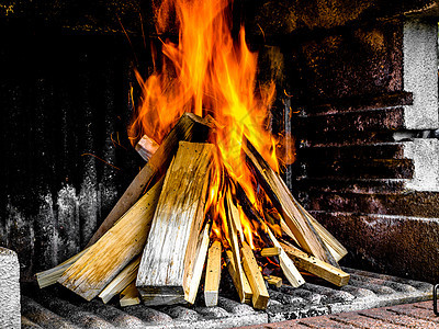 烧柴堆积在混凝土Grill中壁炉火焰日志橙子燃烧木头危险红色余烬营火图片