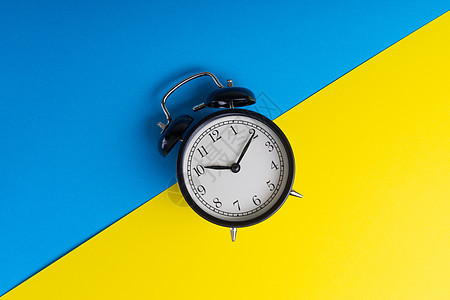 蓝色和黄色背景上的闹钟钟表午餐唤醒工作手表拨号商业数字苏醒倒数图片