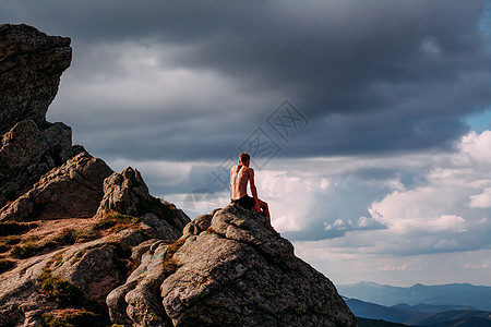 一个人坐在山上的石块上 看着斯坦的面貌图片