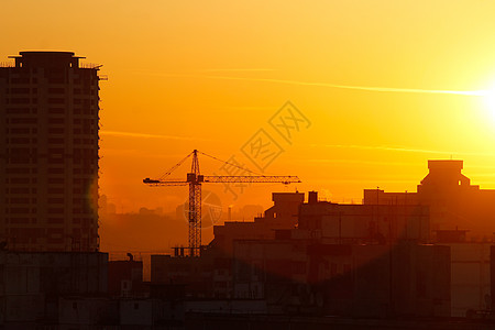 城市背景的橙色日落 骗人的轮廓橙子摩天大楼耀斑阳光建筑蓝色景观艺术街道起重机图片