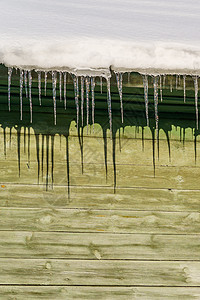 木屋屋檐上的冰柱正在融化晴天危险谷仓高山木头冻结太阳水晶建筑角落图片