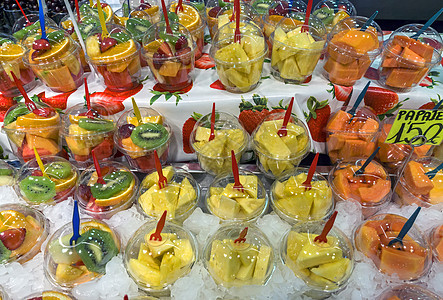 Boqueria市场出售的水果沙拉食物摊位美食店铺果汁奇异果椰子塑料篮子杯子图片