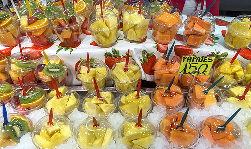 Boqueria市场出售的水果沙拉果汁杯子塑料篮子美食椰子零售摊位店铺奇异果图片