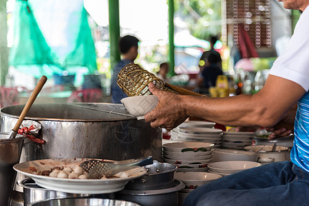 厨师在街头食品市场煮面汤猪肉男人餐厅烹饪文化男性蔬菜餐饮店铺午餐背景图片