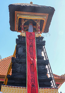 印度尼西亚巴厘岛印度教寺庙 Tanah Lot 的传统巴厘岛宗教和建筑 是一座带钟楼的石塔 用黑白格子布盖的木铃图片