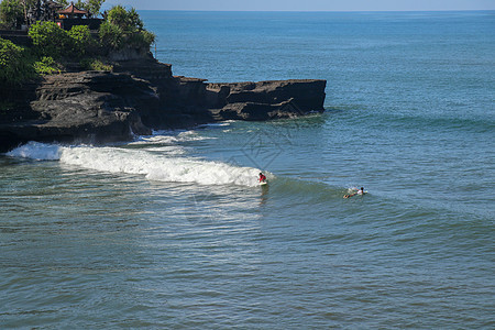 冲浪者在波浪中 抓住波浪 在管道中冲浪 在巴厘岛的海洋中冲浪 一个醇厚的男人 一个纵身跳入大海 从水中取出 从水中拍摄液体男性蓝图片