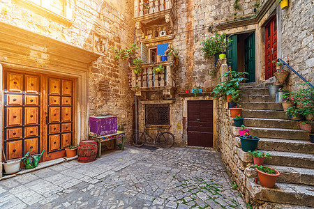 克罗地亚历史城镇Trogir的狭小街口建筑石墙房子石屋建筑学路面地标建筑物旅游古镇图片