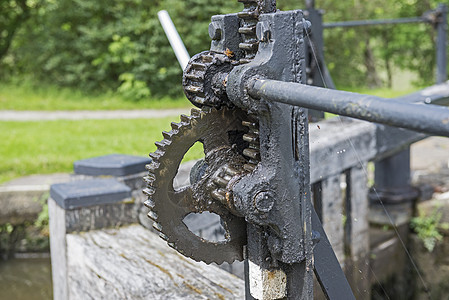 运河锁门上的旧挡风装置润滑脂车轮金属螺栓齿轮铁工运河棘轮工程金工图片