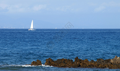 帆船白色游艇桅杆岩石天空地平线港口海洋图片