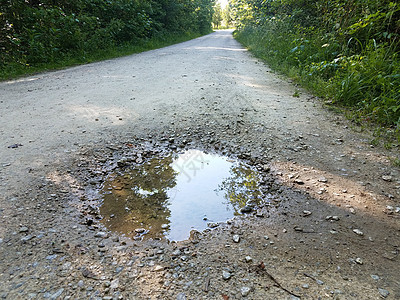 在碎石道或路径上流水的水坑图片