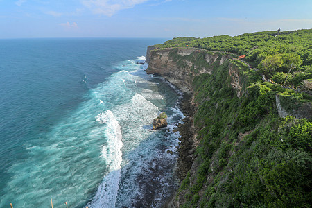 印度尼西亚巴厘岛的乌鲁瓦图悬崖与凉亭和蓝色大海的景色 寺的美丽风景 白天有五颜六色的鲜花前景 高悬崖风景秀丽的沿海景观旅游地平线图片
