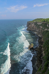 印度尼西亚巴厘岛的乌鲁瓦图悬崖与凉亭和蓝色大海的景色 寺的美丽风景 白天有五颜六色的鲜花前景 高悬崖风景秀丽的沿海景观太阳海滩日图片