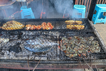 鱼烧烤 在火上烹饪烧烤海鲜 用燃烧的煤烧烤 在金巴兰热带巴厘岛的鱼市场上的优秀 warung 烧烤 新鲜 健康 美味的海鲜香菜对图片