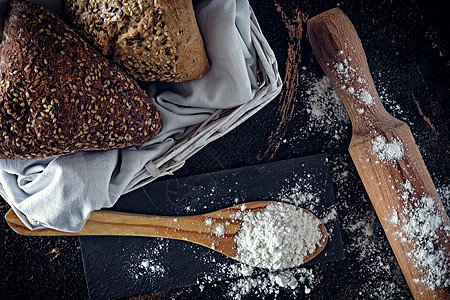 底部有种子的面包 上面有抹布和柳条筐 与面包和柳条筐组成 从上面看厨房 有种子的面包 地中海饮食桌子产品脆皮白色粮食黑色食物美食图片