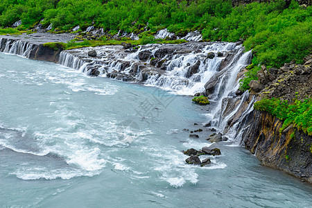 Hraunfossar瀑布火山蓝色溪流流动荒野岩石绿色美丽冰川旅行图片