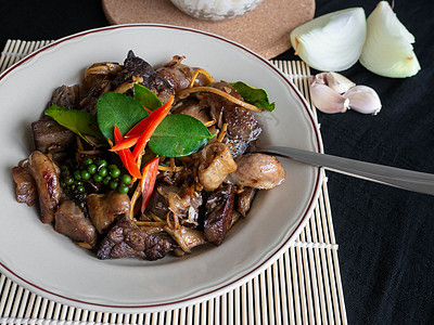 炸猪内脏的名字是 Phad cha 泰国菜 配料是猪肉馅辣椒 Krachai 大蒜洋葱和 Kaffir 石灰叶 杯子里的米饭 背图片