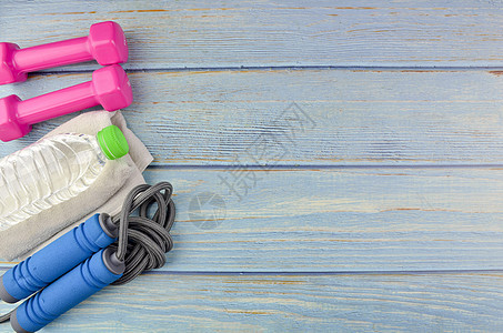 健康概念蓝色哑铃女性重量健身房瓶子训练绳索瑜伽木头图片