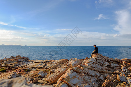 男人坐在岩石上旅行天空风景公园半岛蓝色海岸线假期观光地平线图片