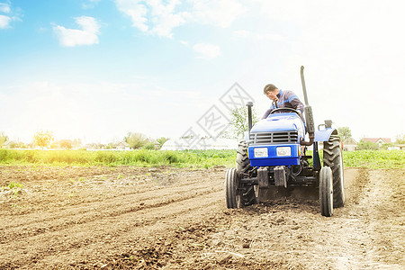 农民在带铣床的拖拉机上松动 研磨和混合土壤 疏松地表 耕种土地以进一步种植 农业和农业 在农场使用农业机械图片