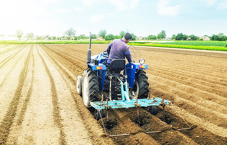 拖拉机上的农民在农田上耕作土墩 准备种植未来农作物的土地 种植用土壤的耕作 农业工业 农业综合企业 欧洲农田图片