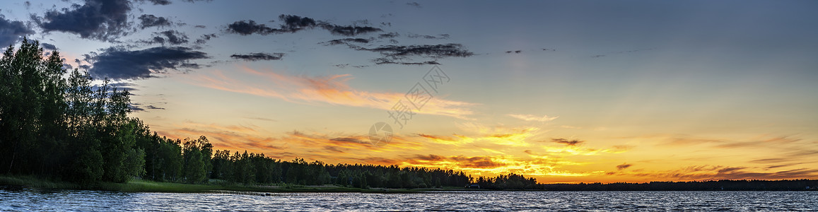 瑞典极地和副极地地区的斯堪的纳维亚白夜 午夜太阳就在地平线下方 太阳光线照亮了大气中最高的云层 海岸线的湖泊和森林背景图片