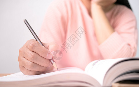在图书馆看书时 女人的手画着一条线 写着简短的总结图片