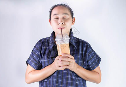 快乐的亚洲年轻女子正在喝泰茶和牛奶 在亚洲流行饮料咖啡店女性女士橙子食物玻璃工作室稻草女孩图片