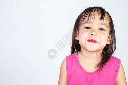 带着红口红的亚洲快乐女孩 穿着粉红色裙子 孤立在白色背景上头发喜悦粉末化妆品模拟女儿家庭女性童年孩子图片