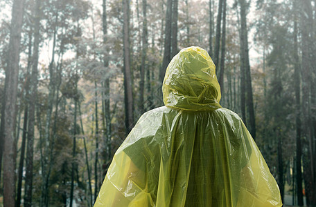 身穿黄雨衣的亚裔女子在雨中站立后座快乐幸福花园微笑季节喜悦雨衣下雨天成人女士图片