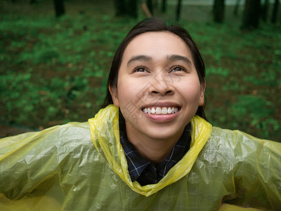 身穿黄雨衣的亚洲快乐妇女肖像雨衣喜悦女士下雨女孩天气头发森林微笑幸福图片