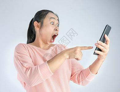 亚洲女性在智能手机中震惊地看到自己所看到的图片