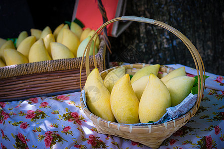 泰国市场上出售的篮子里的黄芒果异国绿色黄色团体艺术食物白色热带红色情调图片