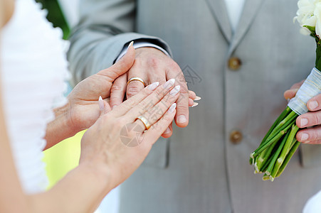 新娘和新郎手与结婚戒指女性婚礼男人庆典珠宝手指白色配偶裙子男性图片