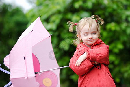 秋天下雨时的可爱小孩女孩乐趣外套农村红色人行道天气雨衣孩子靴子水坑图片